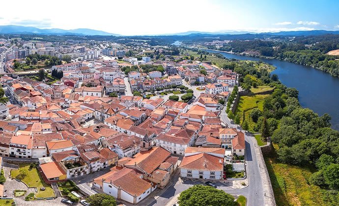A imagem mostra uma vista aérea da vila de Monção, do lado esquerdo e, do lado direito, o rio Minho